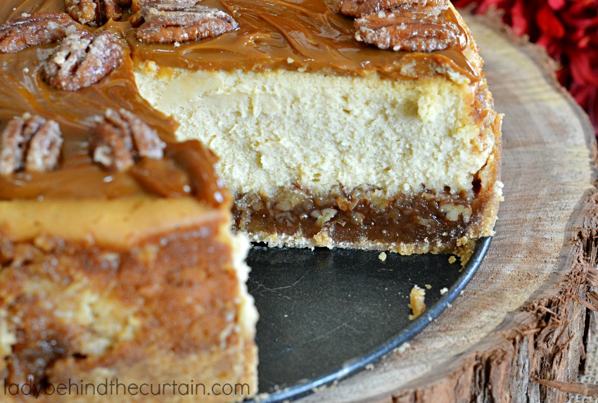 Pecan Pie Cheesecake | A layer of pecan pie filling with a creamy cheesecake center topped with caramel and sugared pecans.
