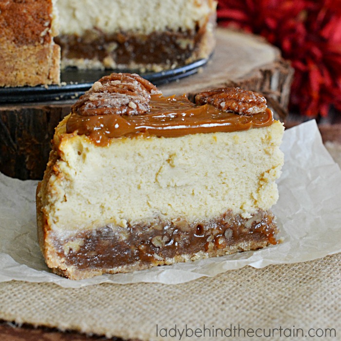 Pecan Pie Cheesecake | A layer of pecan pie filling with a creamy cheesecake center topped with caramel and sugared pecans.