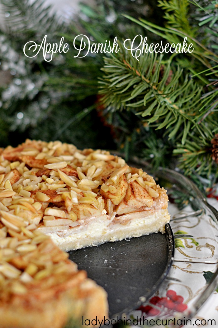 Apple Danish Cheesecake | This cheesecake starts with a delightful almond crust a thin layer of cheesecake all topped with tart apple rolled in a brown sugar cinnamon mixture and almonds.