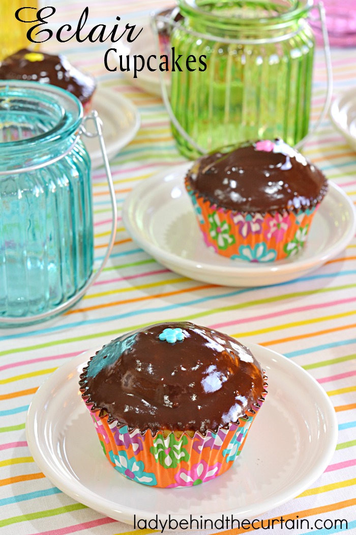 These Eclair Cupcakes are a nod to the popular eclair pastry. With a vanilla pudding filling and dipped in a chocolate ganache. Perfect for any celebration! These are super easy to make. Starting with a cake mix, filled with vanilla pudding and topped with a decadent chocolate ganache!
