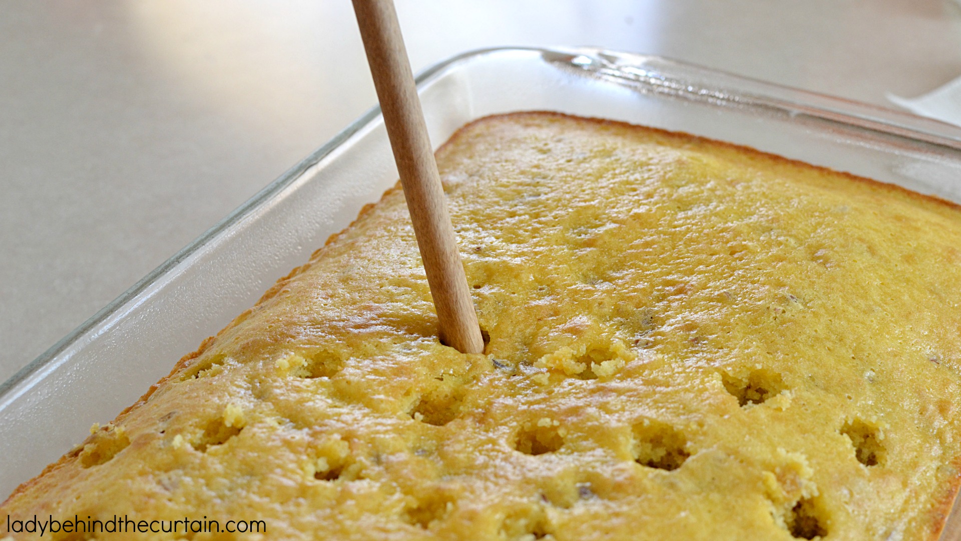 Hummingbird Poke Cake | The perfect potluck cake! Full of pecan, pineapple and banana flavor. 