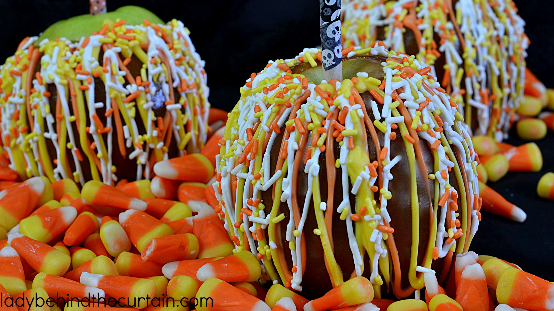 Candy Corn Caramel Apples | Your favorite apple dipped in easy to make caramel and drizzled with festive candy melts plus candy corn colored sprinkles! Perfect for your Halloween Party, Carnival or Fall Festival!